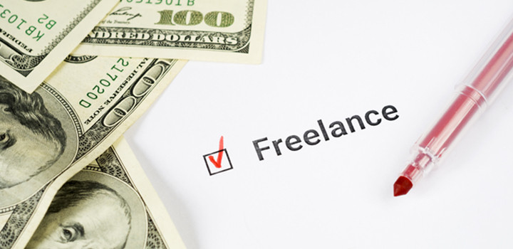 「Freelance」の文字とドル紙幣、赤いペンが置かれた画像