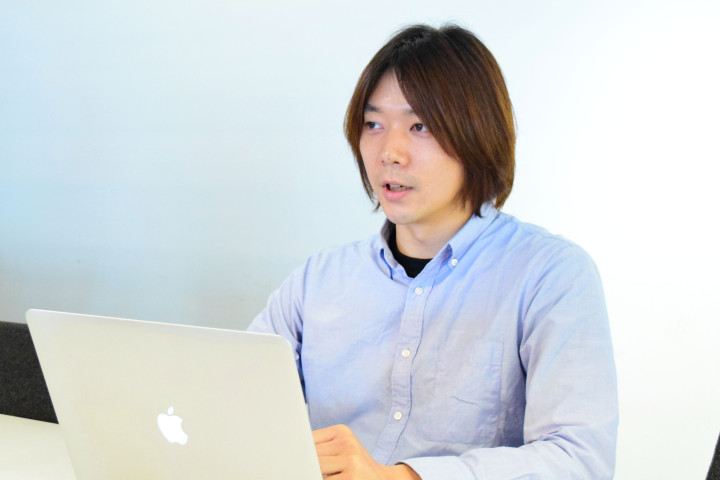 PCの前に座り自身の経歴について語る吉田氏の写真