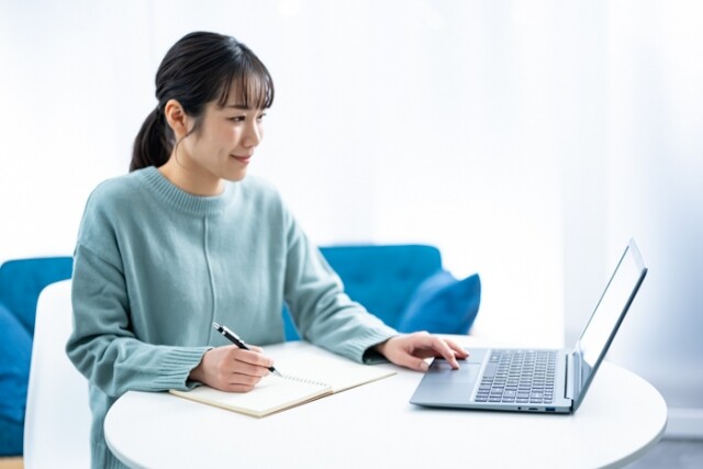 パソコンとノートで勉強をする女性プロジェクトマネージャー