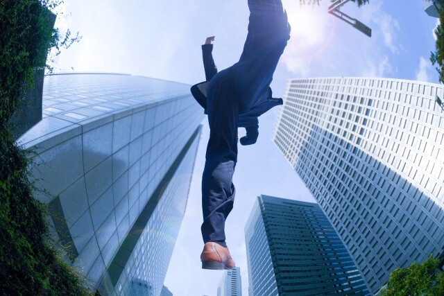 オフィス街をジャンプする男性