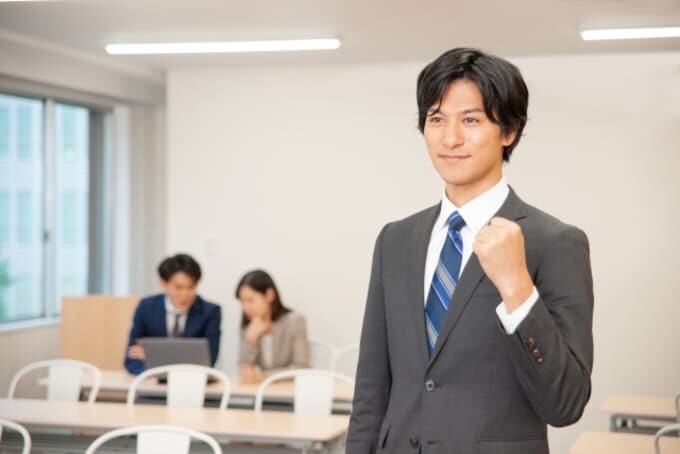 オフィスでガッツポーズをする若い男性