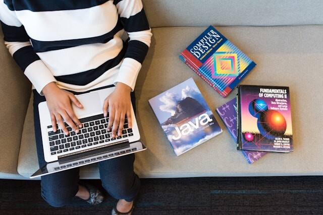 macbookを使用している白と黒の縞模様のトップスを着た人